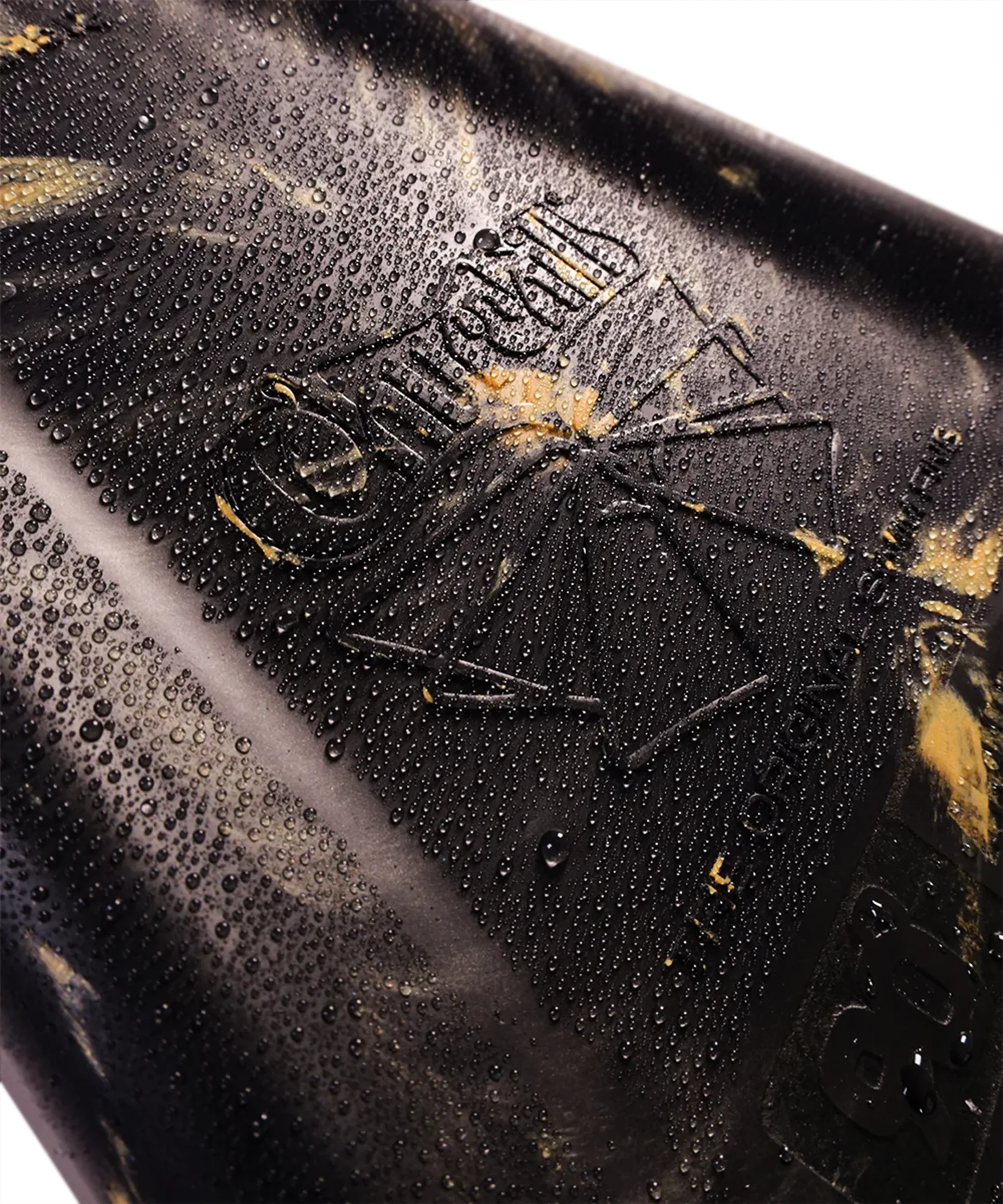 Close-up of black swimfin with water droplets and embossed logo, showcasing durable design for swimming
