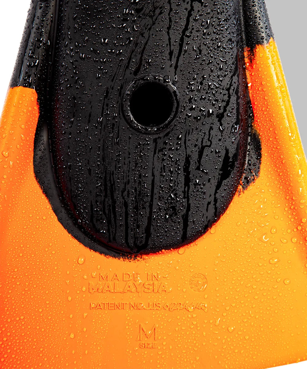 Black and orange swimfin with water droplets, showing size M and 'Made in Malaysia' text