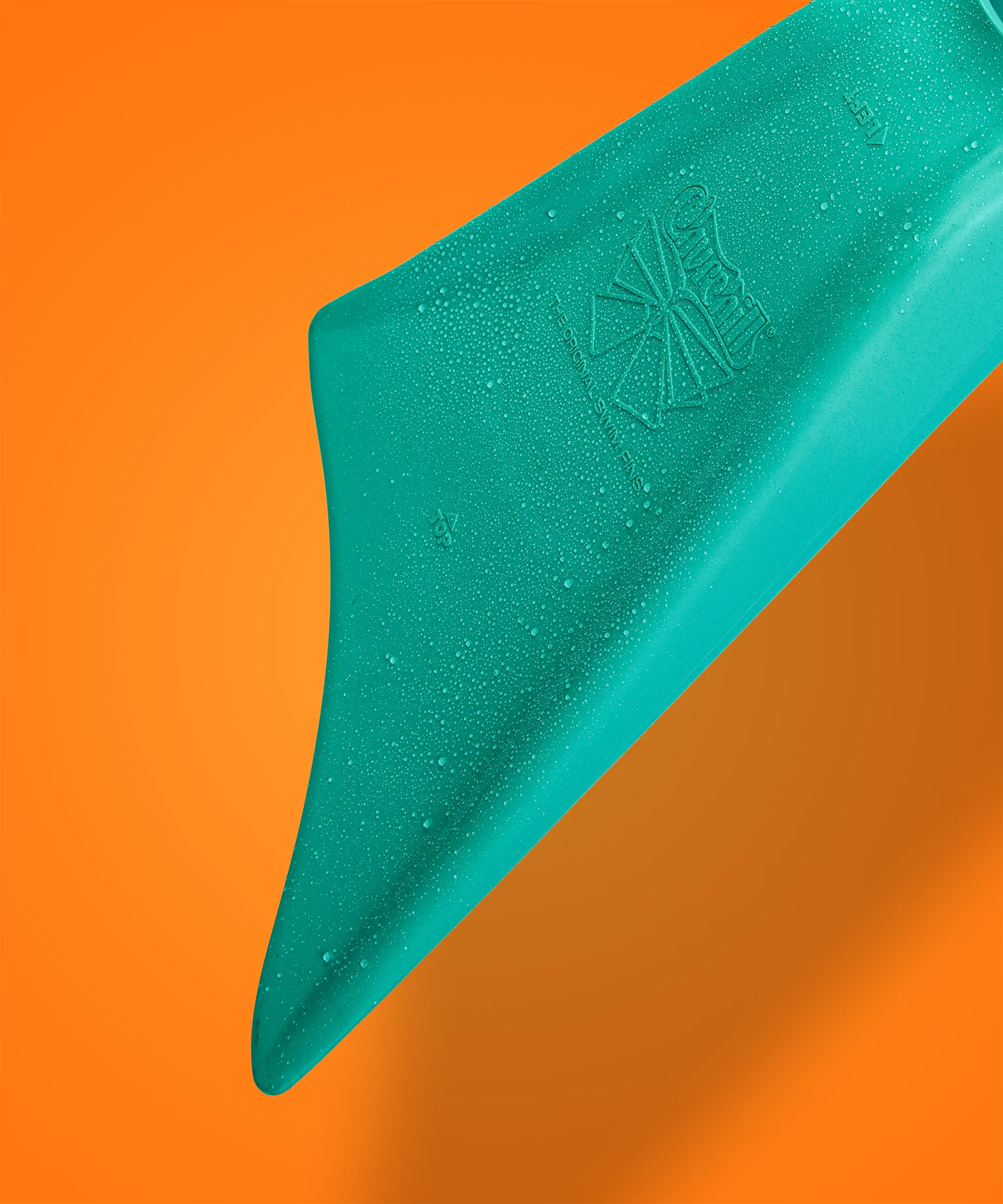 Teal swim fin with water droplets, embossed logo, against orange background