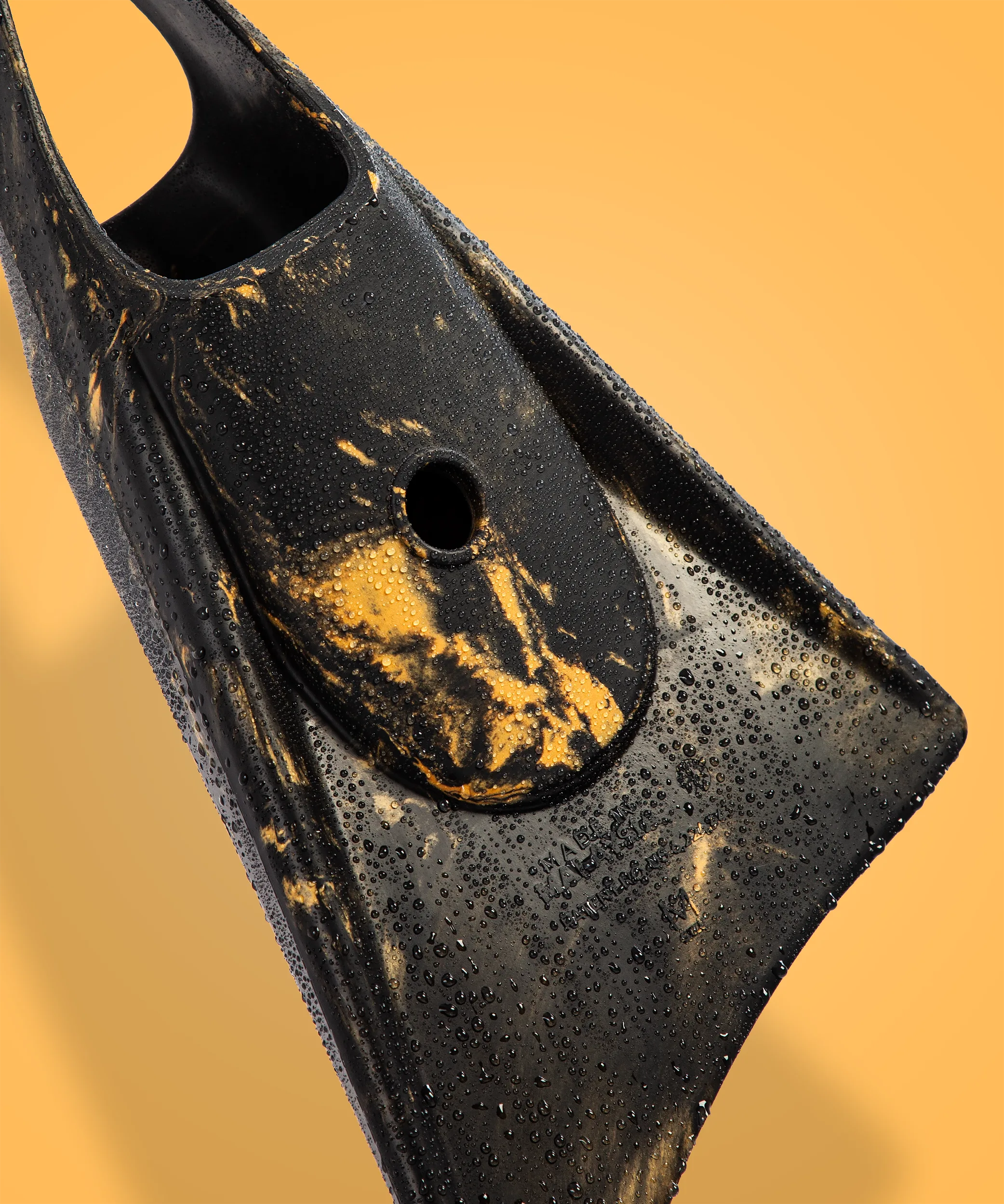 Black swimfin with gold accents and water droplets, showcasing durable design for swimming and diving.