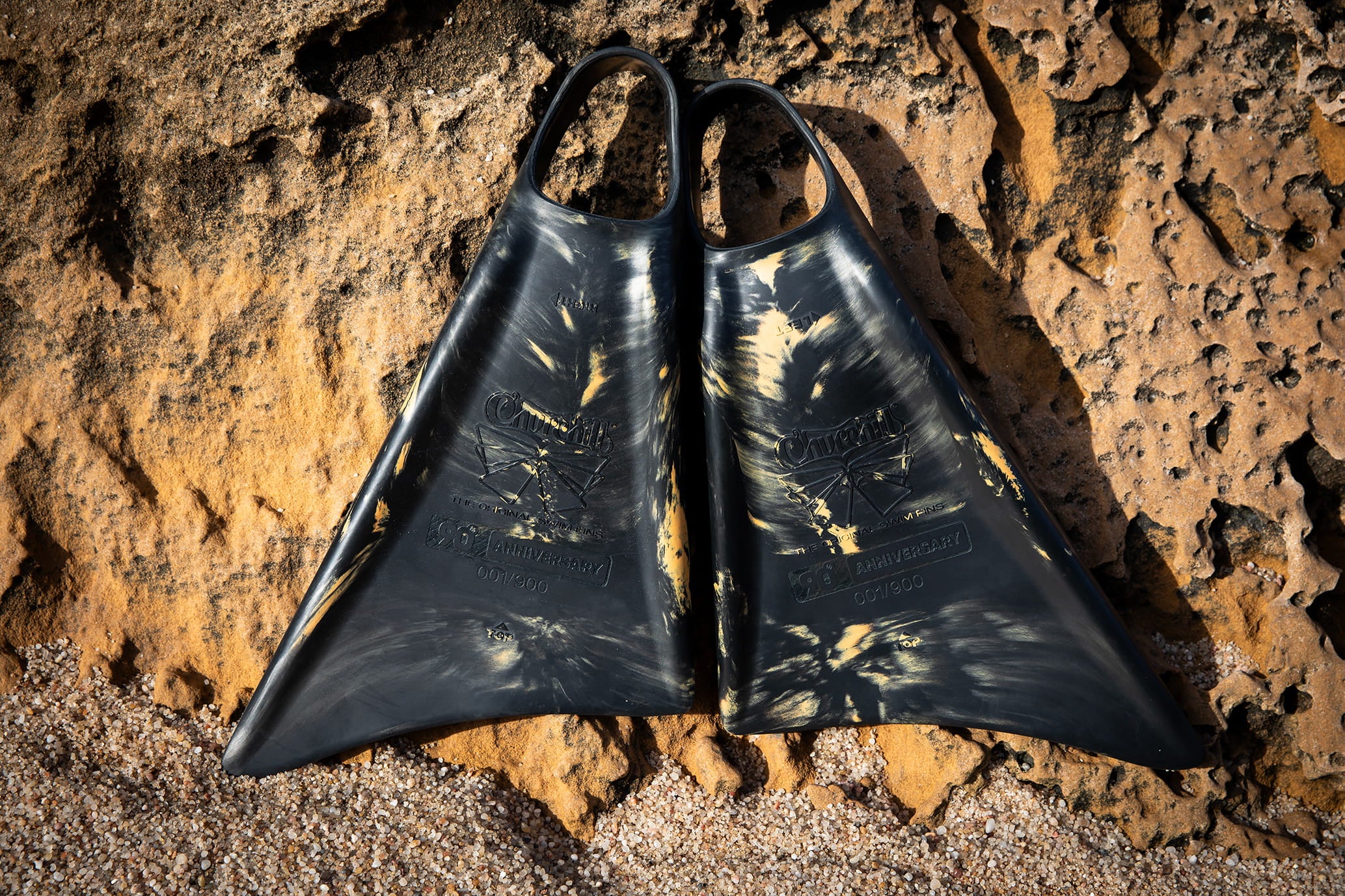 Black and gold Churchill swimfins on rocky beach, 90th anniversary edition, durable design for swimming
