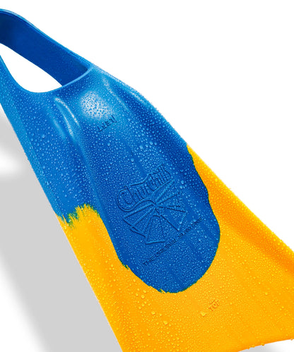 Blue and yellow swimfin with water droplets, featuring embossed brand logo and textured surface for grip.